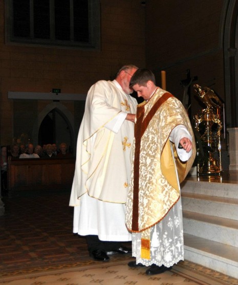 Fr Eric Bryant vests me in the priest's stole and chasuble
